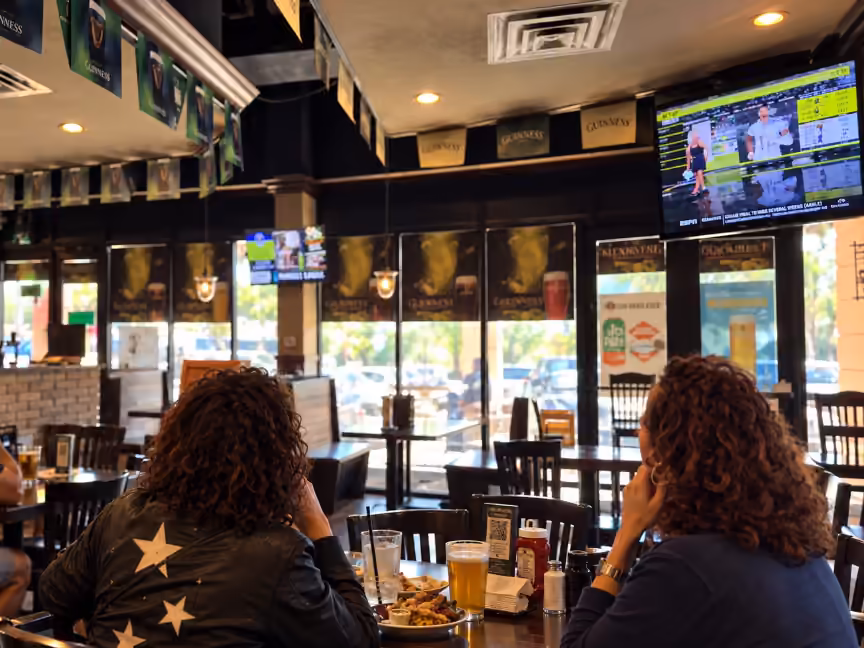 Guests dining under digital screens at Donovan's Irish Pub