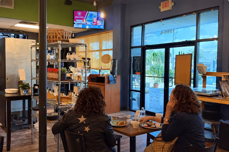 A digital screen above the dining area at Farmhand KCHN and Coffee